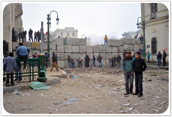 Youth assemble by a wall erected by the army in an effort to put a stop to ongoing clashes. December 2011. Photo: Ali Mustafa